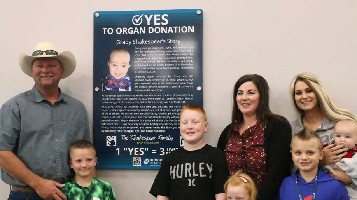 Grady Shakespear's family poses in front of plaque promoting organ donation, which now hangs inside the Cedar City office of Utah Driver License Division as of Dec. 1.