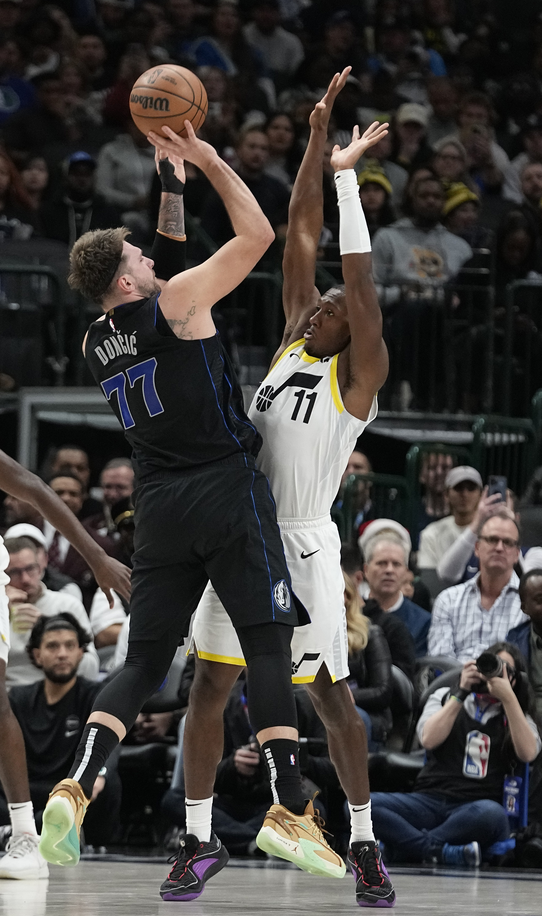 Dallas Mavericks guard Luka Doncic (77) shoots against Utah Jazz guard Kris Dunn (11) during the first half of an NBA basketball game in Dallas, Wednesday, Dec. 6, 2023.