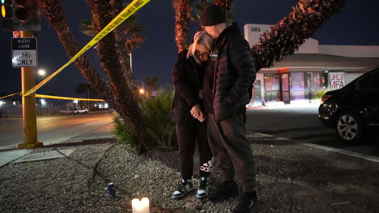 Sean Hathcock, right, kisses Michelle Ashley after the two left candles for victims of a shooting at the University of Nevada, Las Vegas, Wednesday in Las Vegas. The two graduated from the school and live nearby.