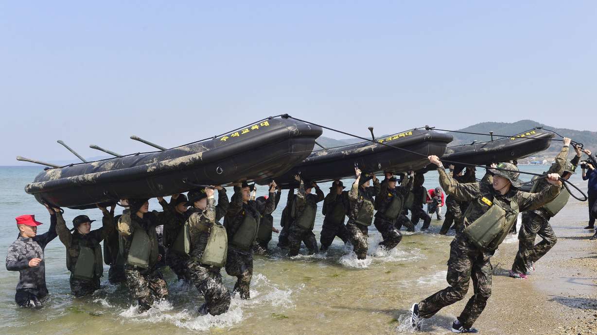 Members of the women's South Korean national handball team perform a team-building exercise with rubber boats during physical training at a boot camp for the Marine Corps in Pohang, South Korea, on March 30, 2016.