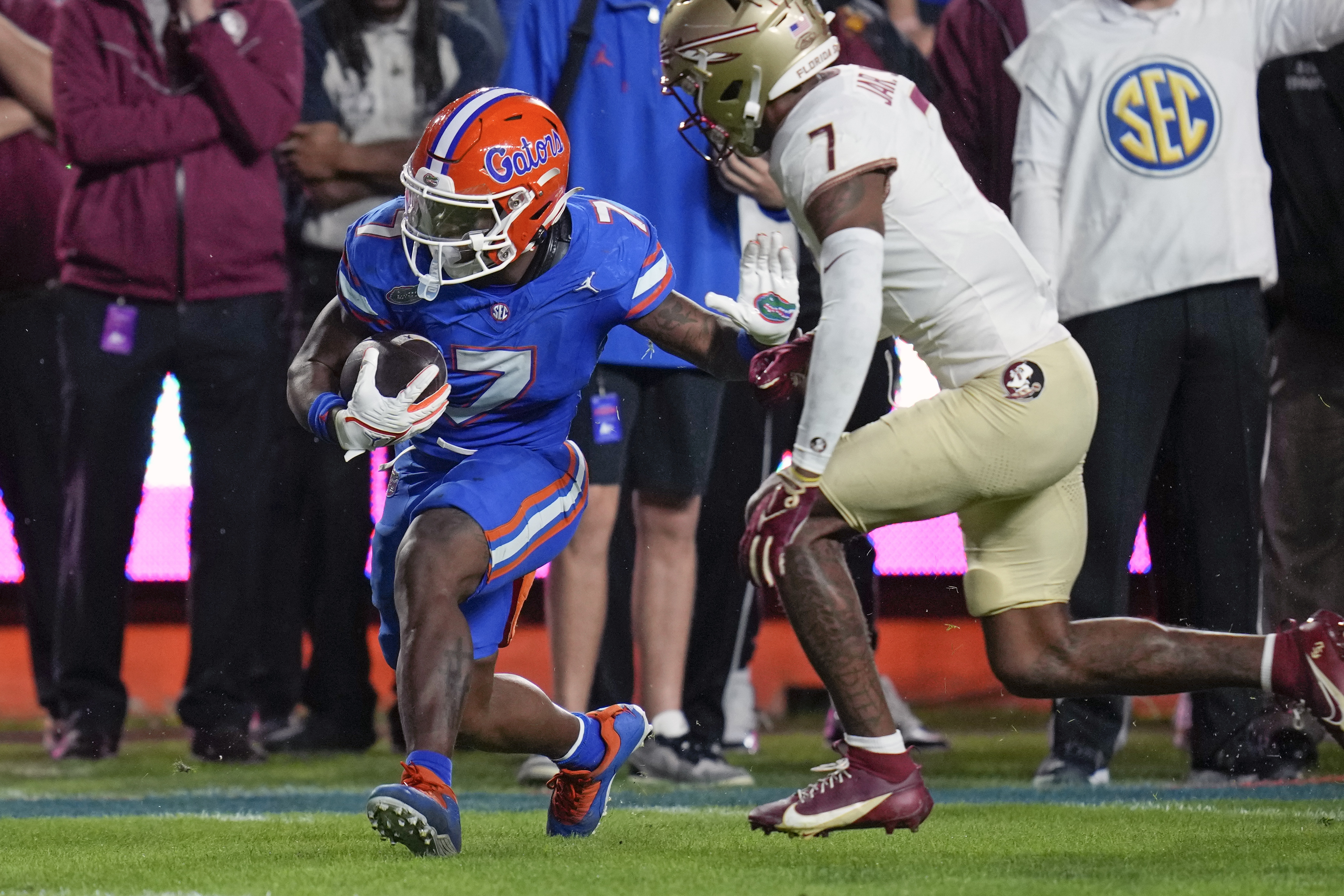 Florida running back Trevor Etienne, left, gains yardage before Florida State defensive back Jarrian Jones, right, can stop him during the first half of an NCAA college football game Saturday, Nov. 25, 2023, in Gainesville, Fla.
