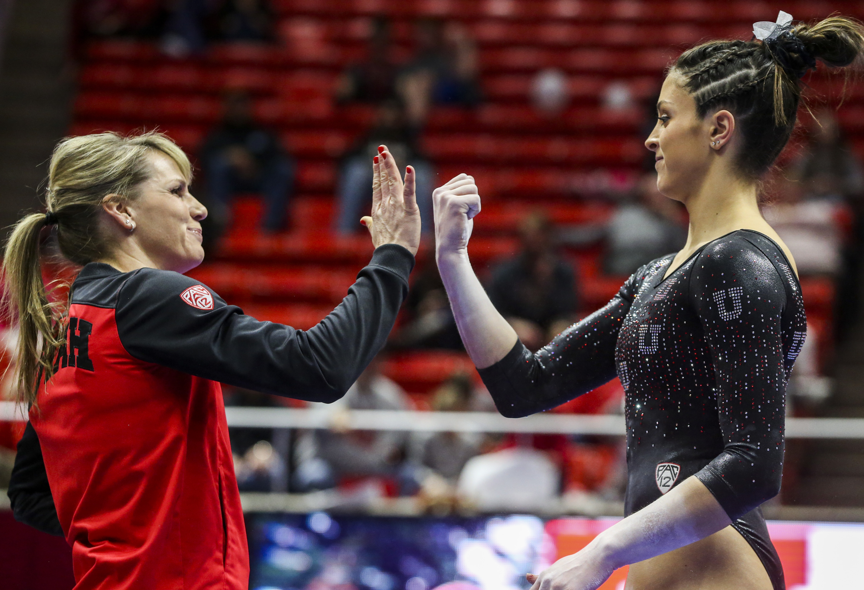 Utah gymnastics assistant coach Carly Dockendorf high-fives gymnast Emilie LeBlanc before she competes on the beam during the Red Rocks Preview gymnastics event at the Jon M. Huntsman Center on the University of Utah campus in Salt Lake City on Friday, Dec. 13, 2019.