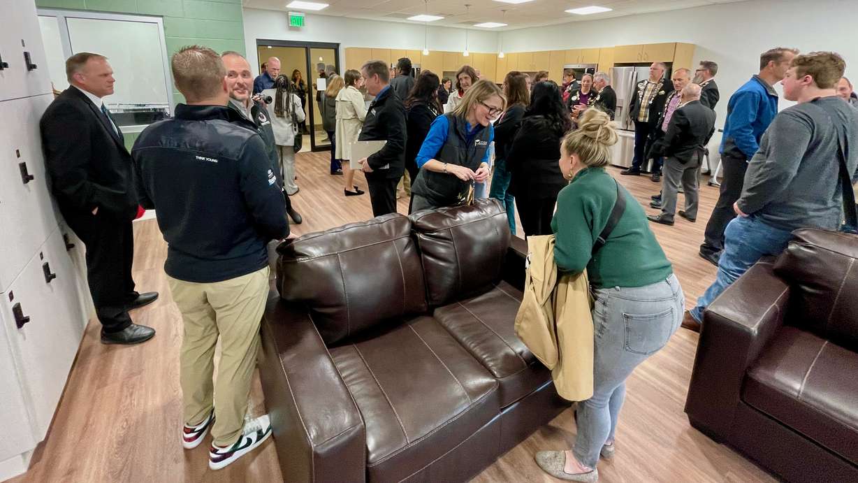 Ogden school officials gathered Dec. 7, 2023, to formally open a center at Odyssey Elementary meant to help homeless students and their families. Odyssey Principal Sonja Davidson is in the center, with blue sleeves.