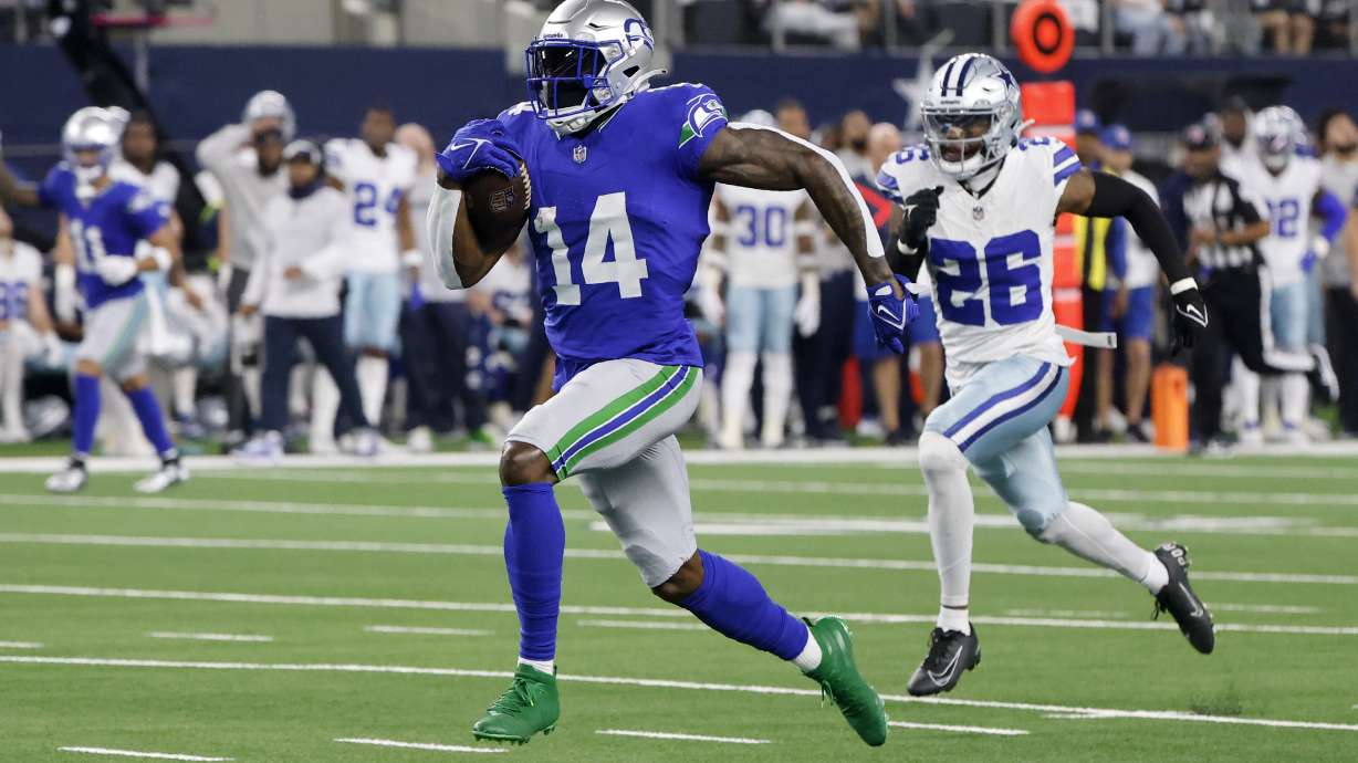 Seattle Seahawks wide receiver DK Metcalf (14) sprints to the end zone to score a touchdown after making a catch as Dallas Cowboys cornerback DaRon Bland (26) gives chase in the first half of an NFL football game in Arlington, Texas, Thursday, Nov. 30, 2023.