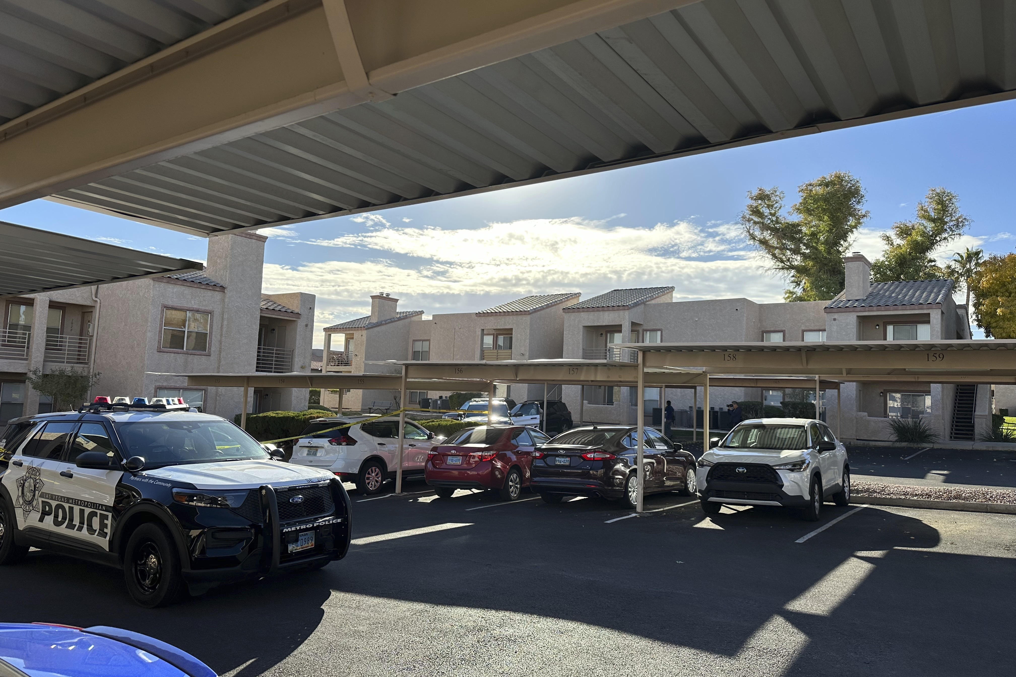 Police are stationed outside of an upstairs corner apartment, Thursday, in Henderson, Nev., where the suspect in a fatal shooting at the University of Nevada, Las Vegas, lived.