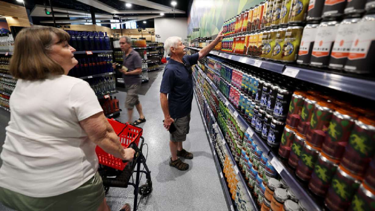 Debbie Wolf and Michael Wolf look at the wall of Utah produced products at the new State Liquor Store in Sandy on July 31. Now through the end of February, every liquor store in Utah will collect donations for dozens of local charities.