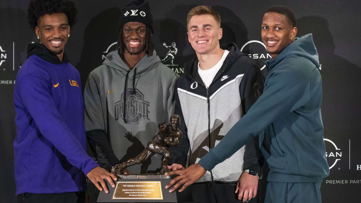 Heisman Trophy finalists, from left, LSU quarterback Jayden Daniels, Ohio State wide receiver Marvin Harrison Jr., Oregon quarterback Bo Nix and Washington quarterback Michael Penix Jr. pose for a photo with the Heisman Trophy, Friday, Dec. 8, 2023, in New York. The Heisman Trophy will be announced Saturday, Dec. 9.