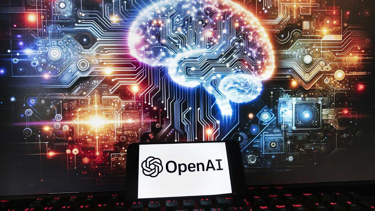 The OpenAI logo is displayed on a cellphone with an image on a computer monitor generated by ChatGPT's Dall-E text-to-image model, Friday, in Boston. European Union negotiators have clinched a deal on the world's first comprehensive artificial intelligence rules.