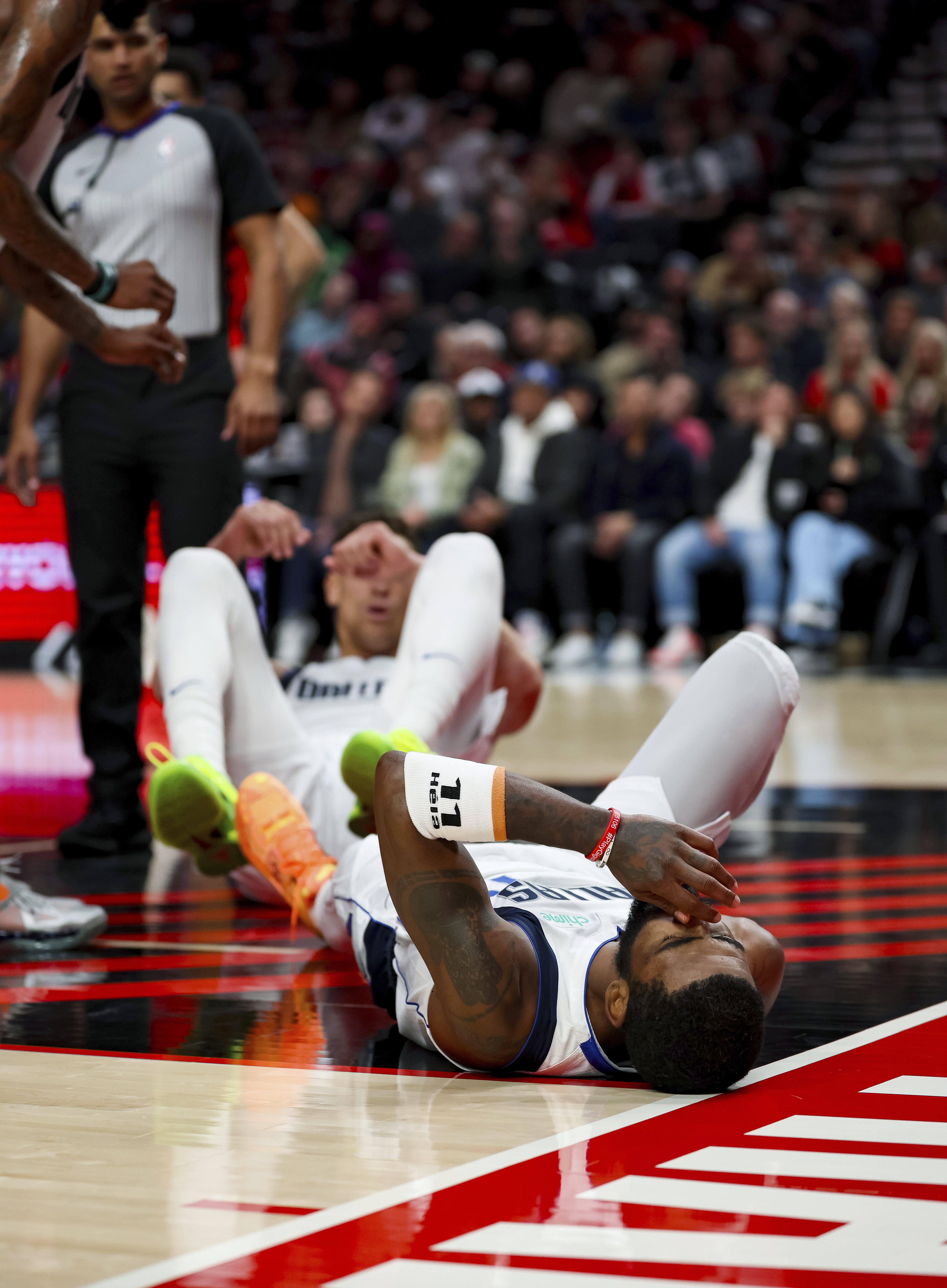 Dallas Mavericks guard Kyrie Irving lies on the court after falling during the first half of the team's NBA basketball game against the Portland Trail Blazers on Friday, Dec. 8, 2023, in Portland, Ore.