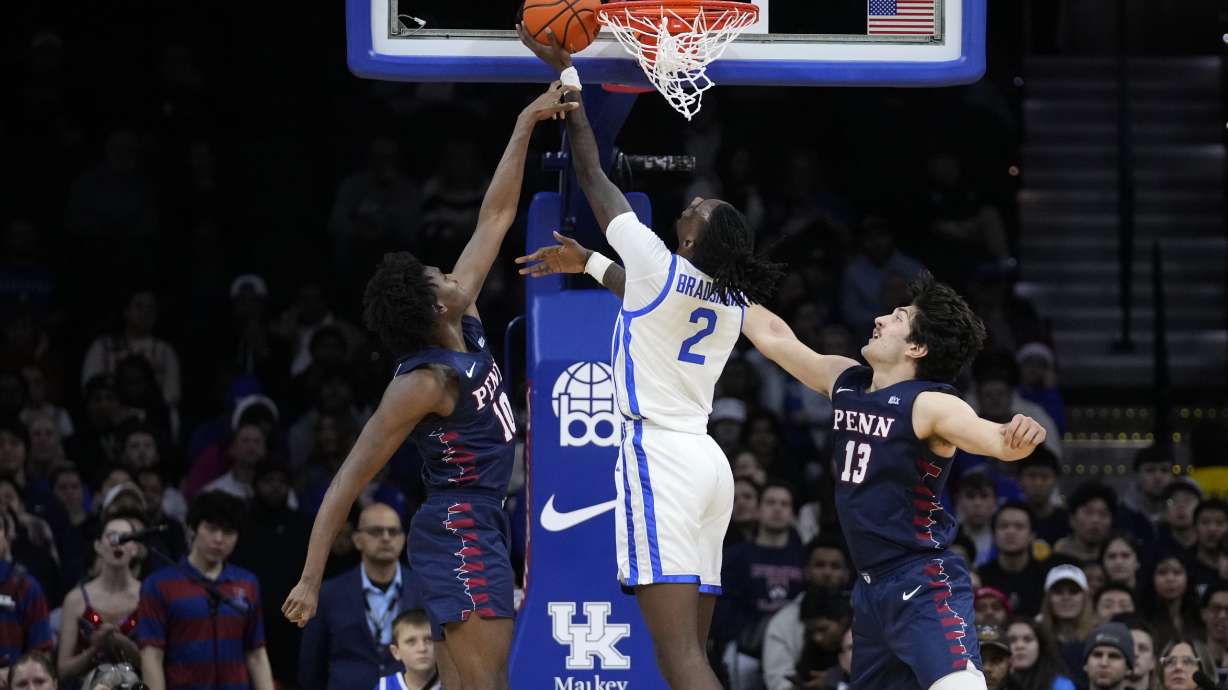 Kentucky's Aaron Bradshaw, center, goes up for a shot against Pennsylvania's Eddie Holland III, left, and Nick Spinoso during the first half of an NCAA college basketball game, Saturday, Dec. 9, 2023, in Philadelphia.