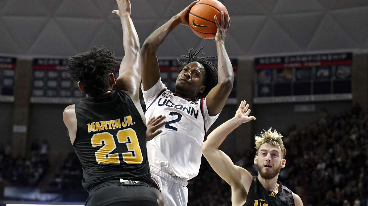 UConn guard Tristen Newton (2) is fouled by Arkansas-Pine Bluff forward Lonnell Martin Jr. (23) in the first half of an NCAA college basketball game, Saturday, Dec. 9, 2023, in Storrs, Conn.