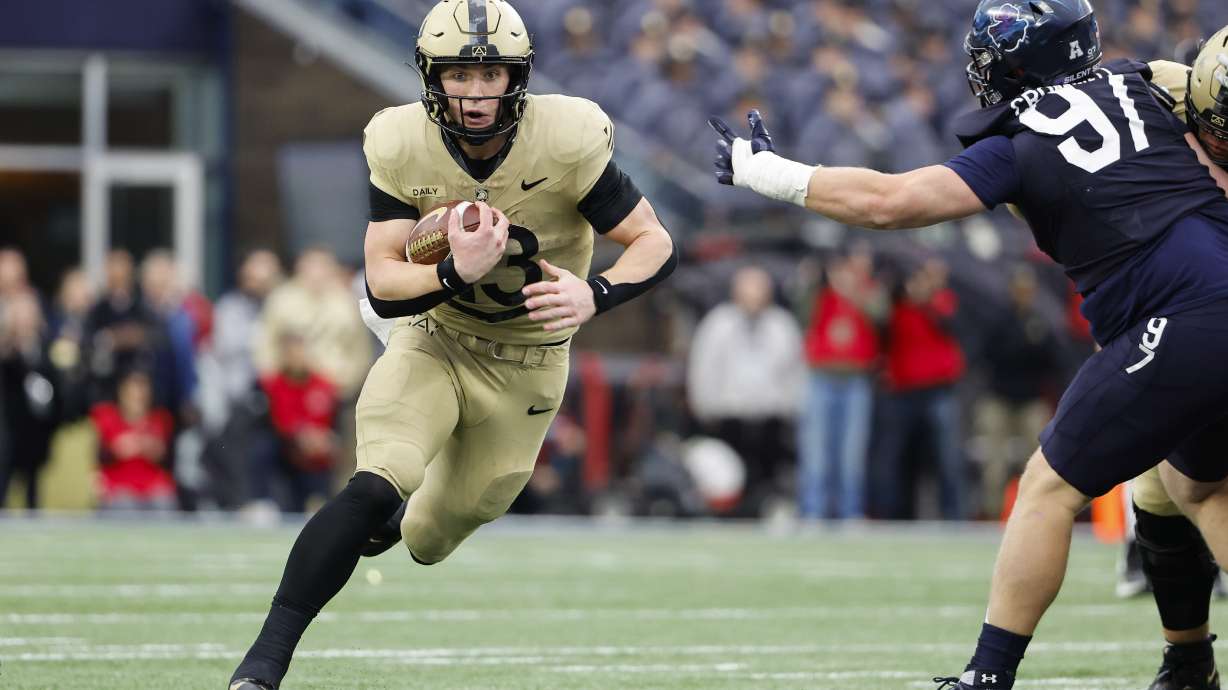 Army quarterback Bryson Daily runs through a hole past Navy defensive tackle Clay Cromwell during the first quarter of an NCAA football game at Gillette Stadium Saturday, Dec. 9, 2023, in Foxborough, Mass.