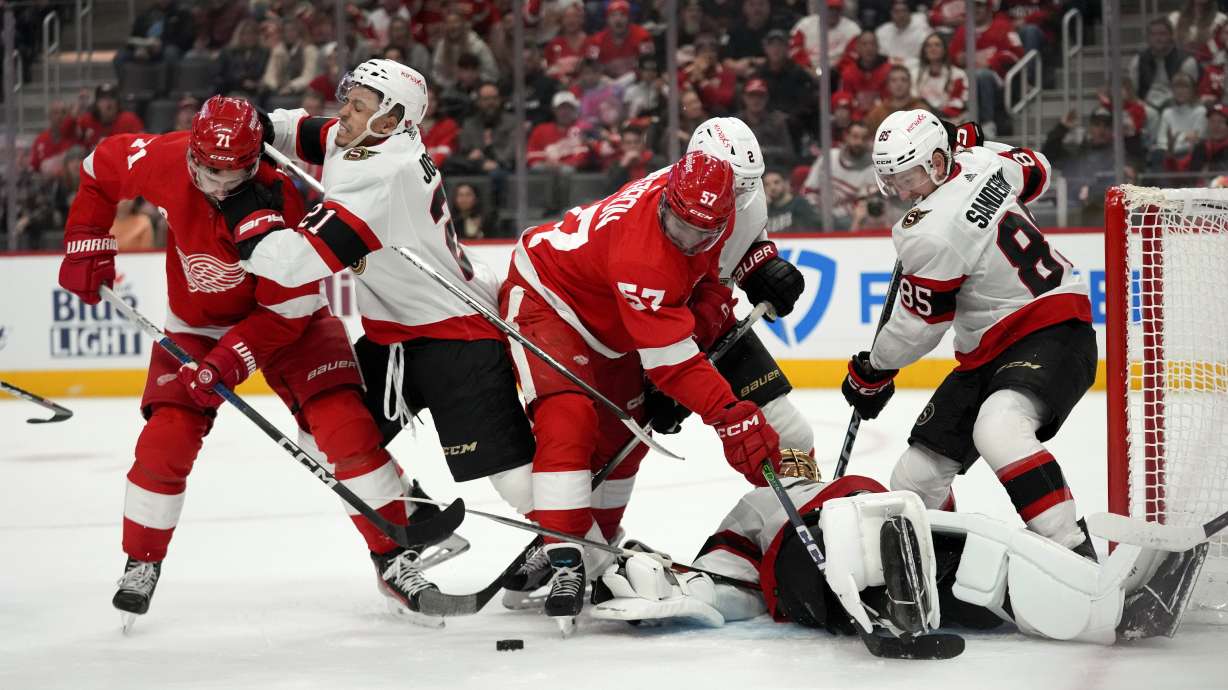 Ottawa Senators right wing Mathieu Joseph (21) hits Detroit Red Wings center Dylan Larkin (71) in the first period of an NHL hockey game Saturday, Dec. 9, 2023, in Detroit.