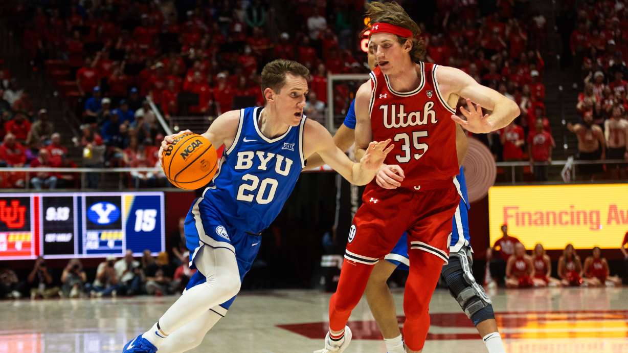 Brigham Young guard Spencer Johnson (20) drives the ball with Utah Utes center Branden Carlson (35) on defense during a men’s basketball game at the Jon M. Huntsman Center in Salt Lake City on Saturday, Dec. 9, 2023.