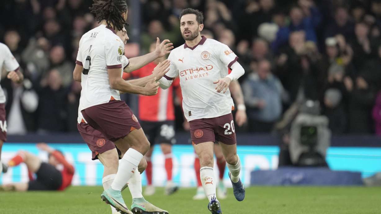 Manchester City's Bernardo Silva is congratulated after scoring his side's first goal during the English Premier League soccer match between Luton Town and Manchester City at Kenilworth Road stadium in Luton, England, Sunday Dec. 10, 2023.