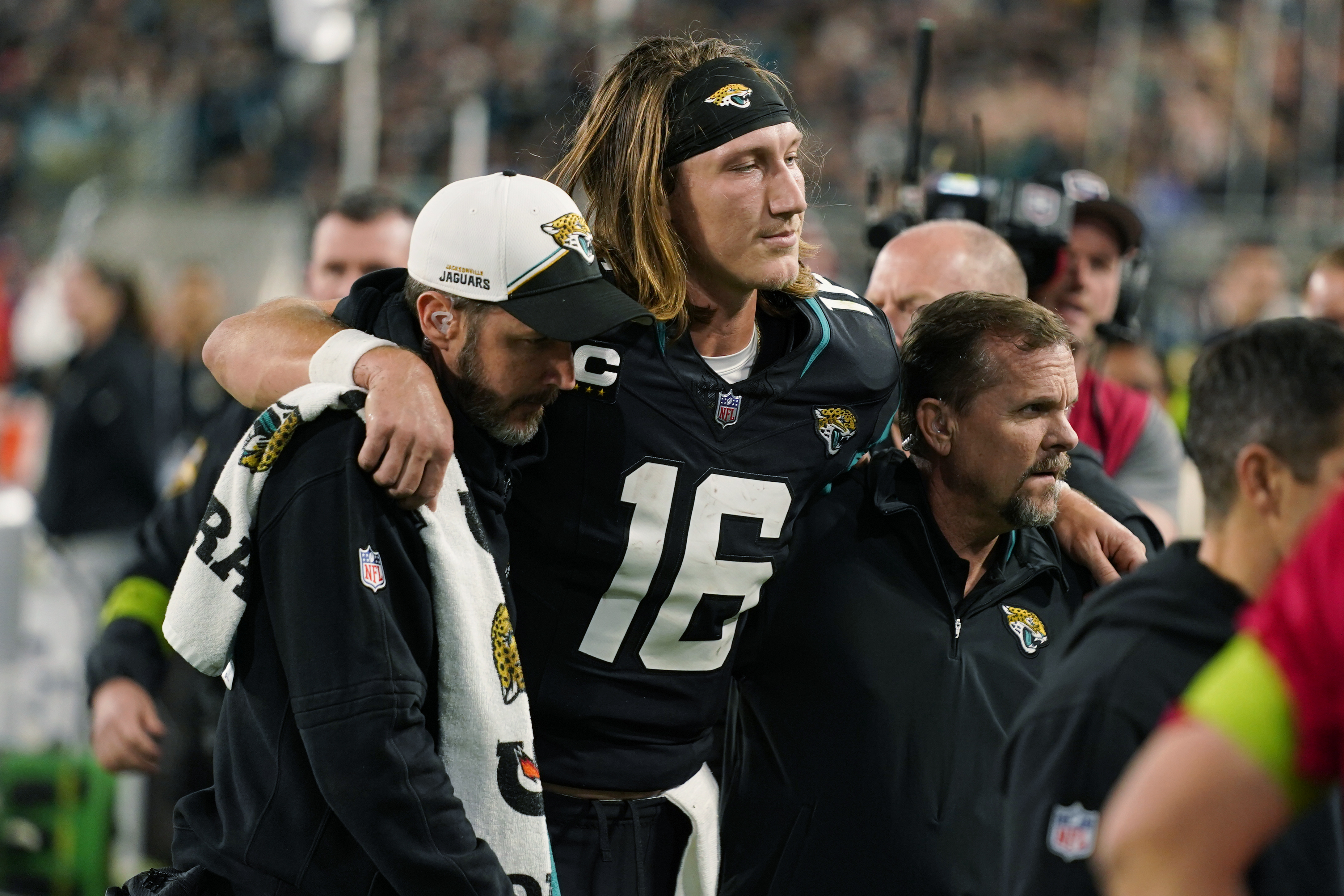Jacksonville Jaguars quarterback Trevor Lawrence (16) is assisted off the field after he was injured during the second half of an NFL football game against the Cincinnati Bengals, Monday, Dec. 4, 2023, in Jacksonville, Fla.