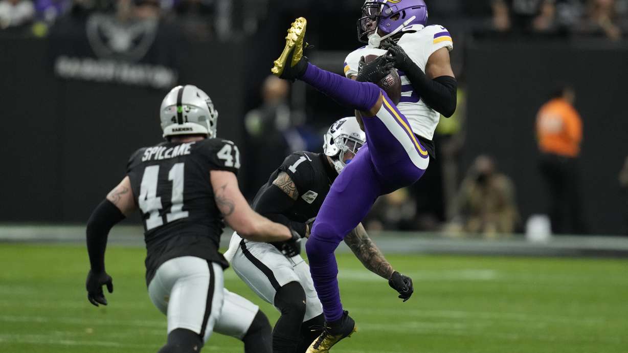 Minnesota Vikings wide receiver Justin Jefferson (18) makes a catch as Las Vegas Raiders safety Marcus Epps (1) defends during the first half of an NFL football game, Sunday, Dec. 10, 2023, in Las Vegas.