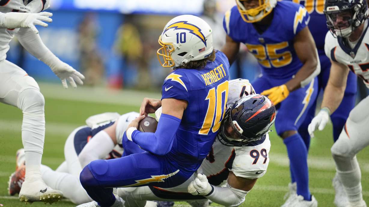 Denver Broncos defensive end Zach Allen (99) sacks Los Angeles Chargers quarterback Justin Herbert (10) during the first half of an NFL football game Sunday, Dec. 10, 2023, in Inglewood, Calif.