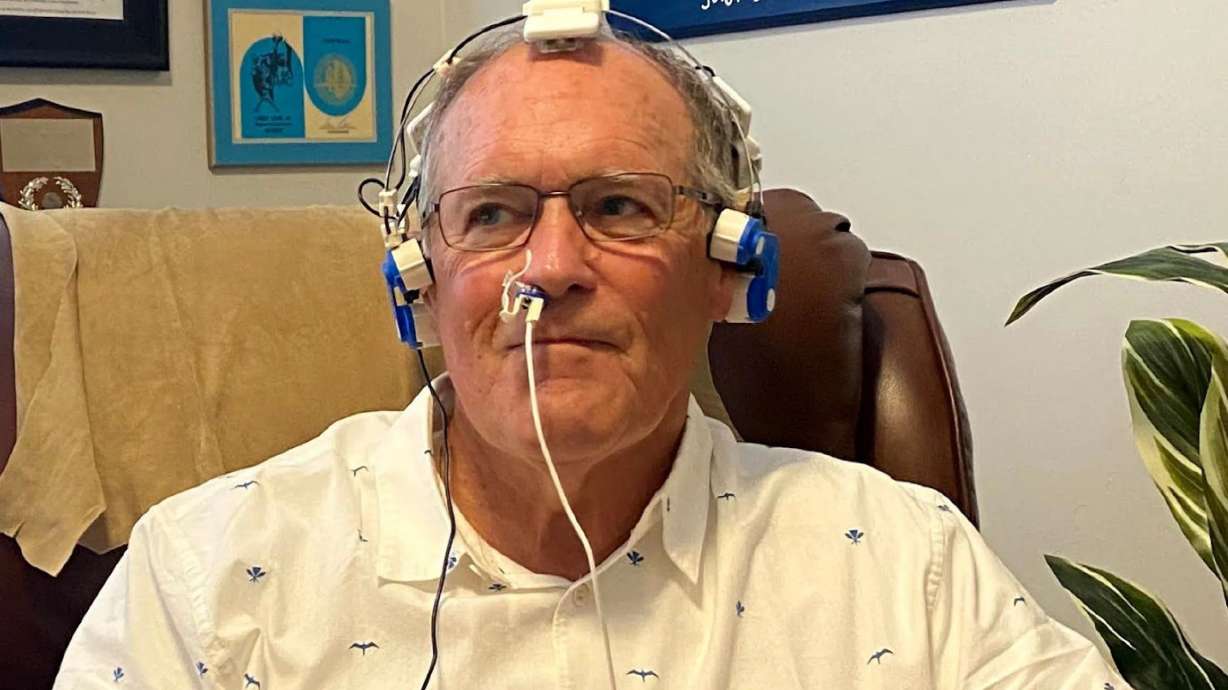 Former college and pro linebacker Larry Carr wears a Vielight headset during an infrared light therapy session. Carr is trying to spread the word about an infrared light therapy that helped ease his symptoms associated with playing football.
