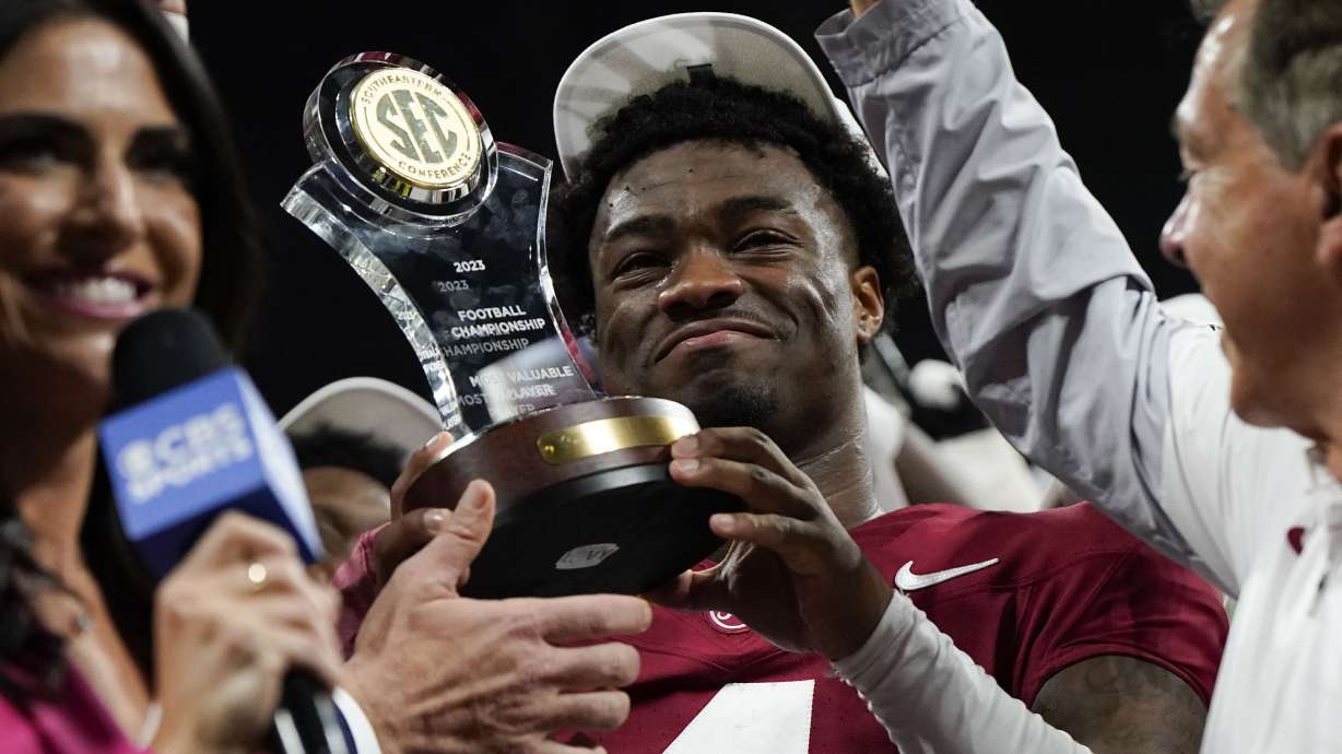 Alabama quarterback Jalen Milroe (4) holds up the most valuable player trophy after the Southeastern Conference championship NCAA college football game against Georgia in Atlanta, Saturday, Dec. 2, 2023.