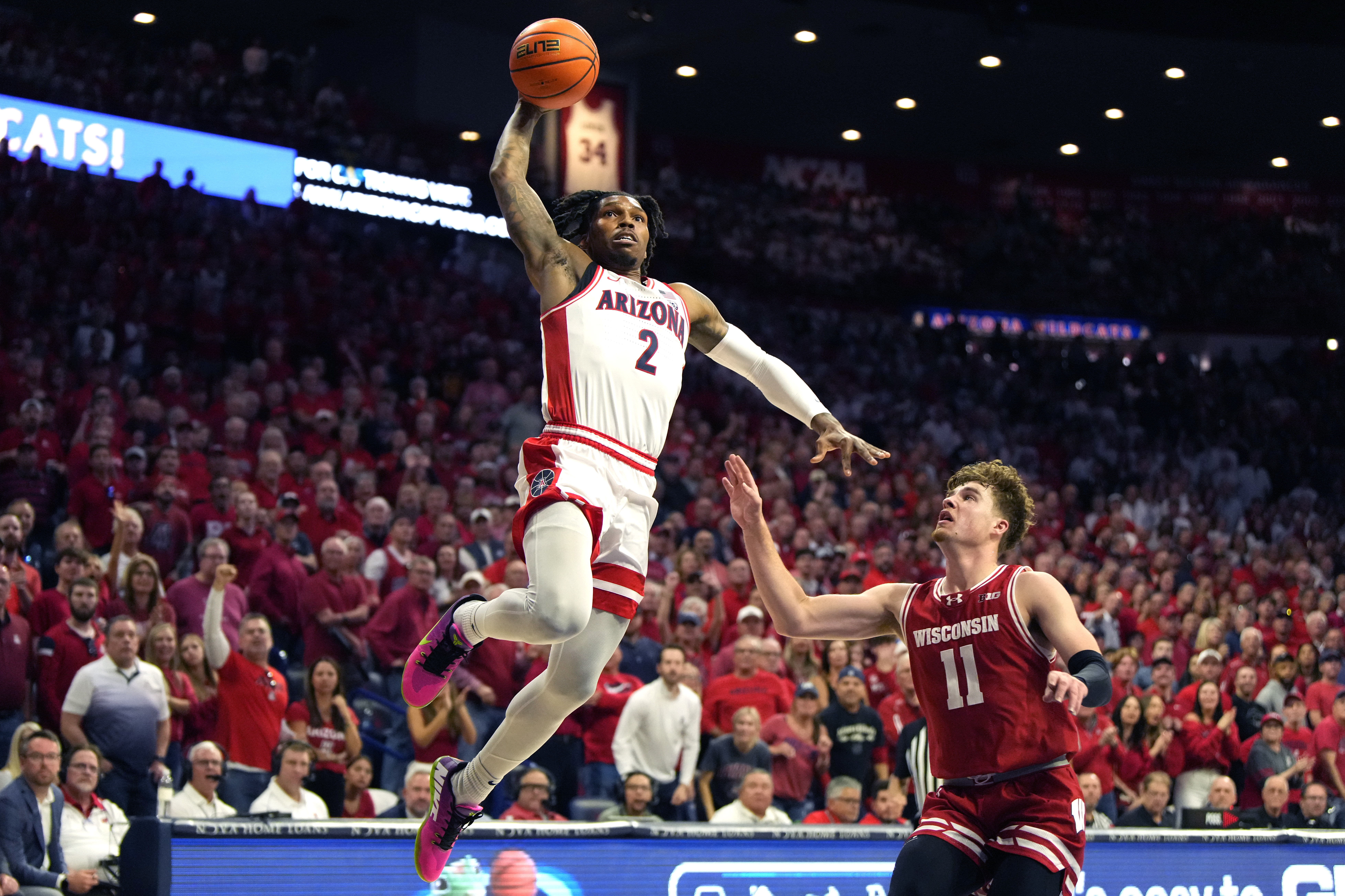 Arizona guard Caleb Love (2) dunks over Wisconsin guard Max Klesmit (11) during the first half of an NCAA college basketball game, Saturday, Dec. 9, 2023, in Tucson, Ariz.