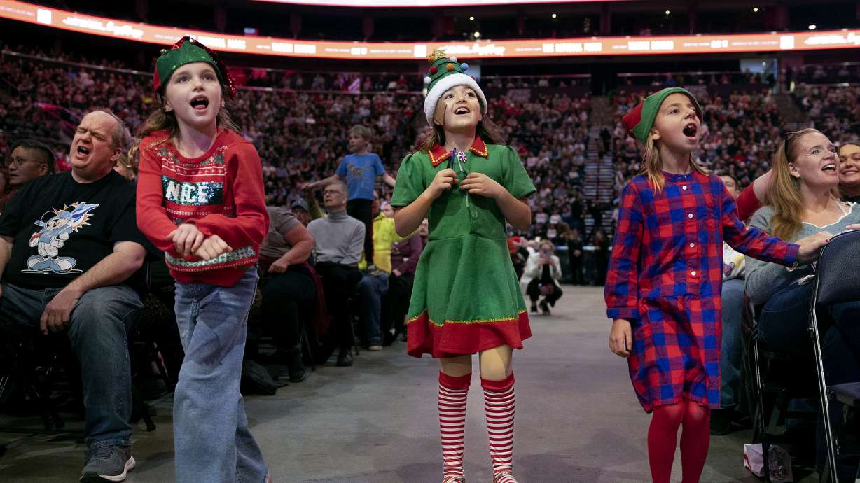 Ruby Yates, Aria Holbrook and Millie Airhart of Salt Lake City participate in the 39th Annual Holiday Sing-Along at the Delta Center in Salt Lake City on Monday.