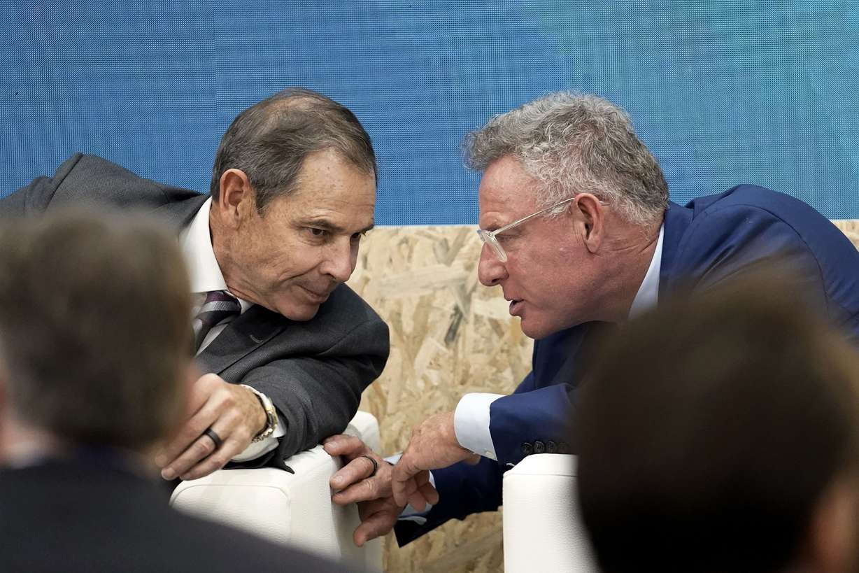 U.S. Rep. John Curtis, of Utah, left, and Rep. Scott Peters, D-Calif., talk during an event at the COP28 United Nations Climate Summit on Dec. 9, in Dubai, United Arab Emirates.