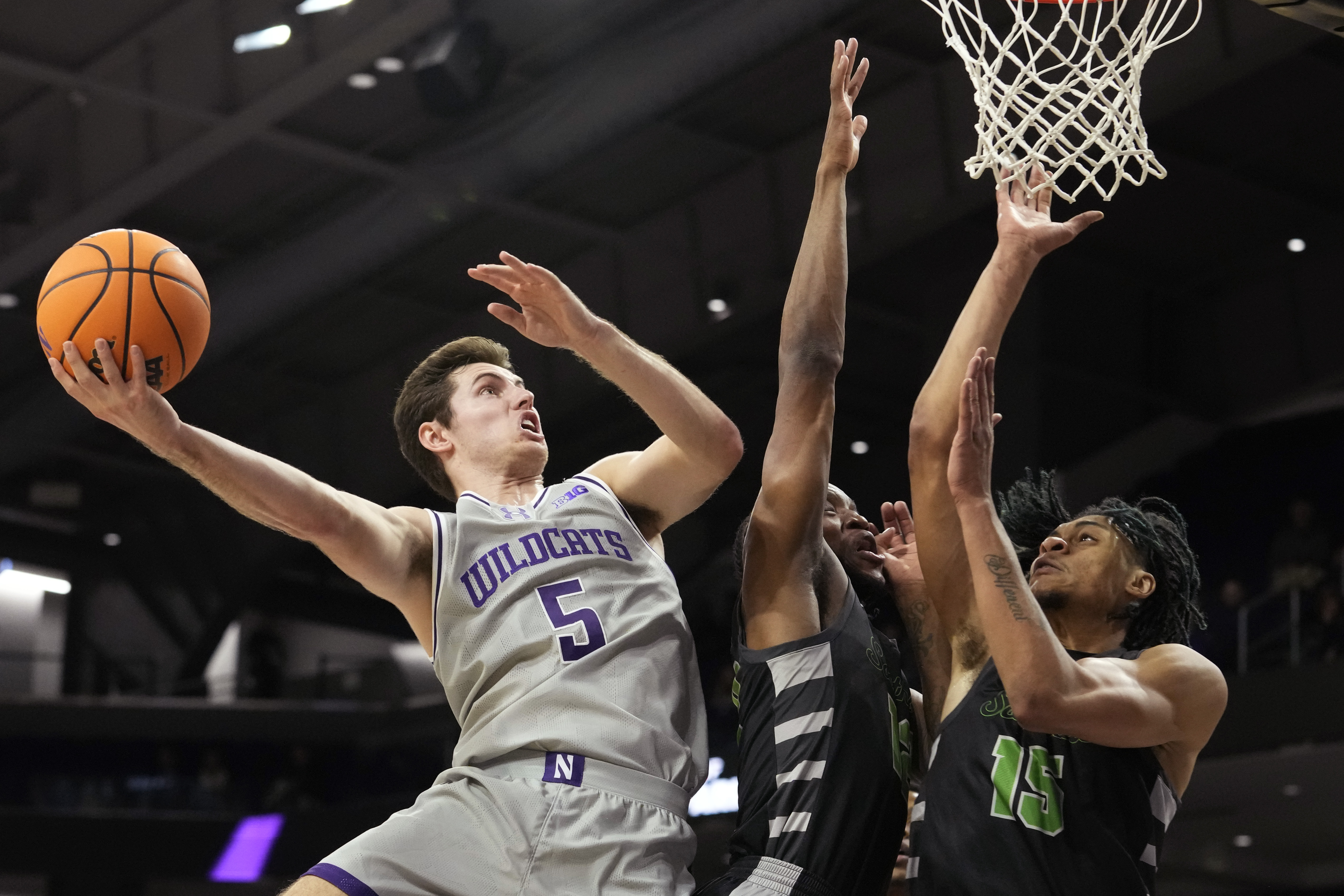 Northwestern guard Ryan Langborg, left, drives to the basket against Chicago State guard Brent Davis, center, and forward Noble Crawford during the first half of an NCAA college basketball game in Evanston, Ill., Wednesday, Dec. 13, 2023. 