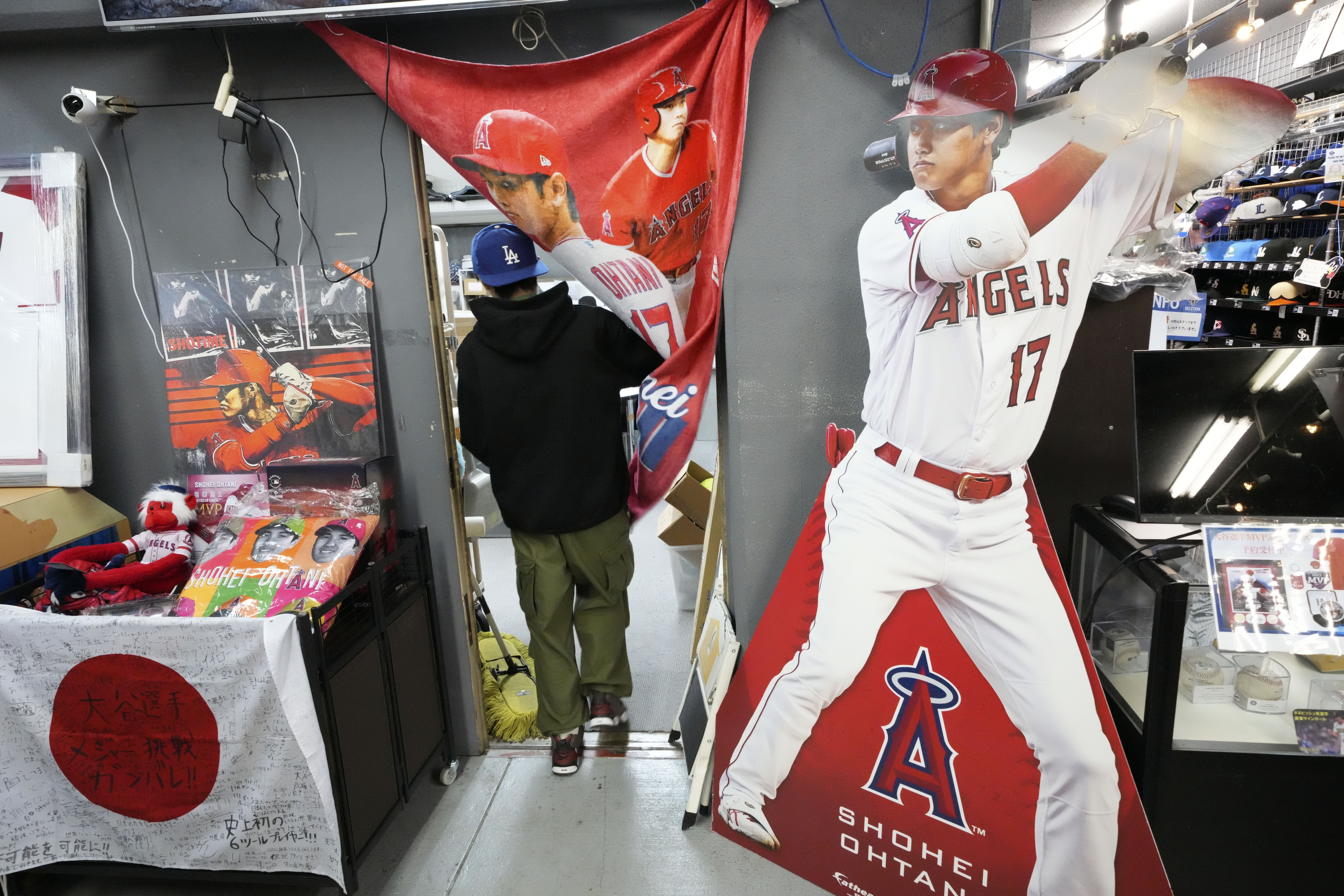 A staff member walks in his office near character goods of Shohei Ohtani of the Los Angeles Dodgers at a sporting goods store, "SELECTION," in Shinjuku district Wednesday, Dec. 13, 2023, in Tokyo. Ohtani agreed to a record $700 million, 10-year contract with the Los Angeles Dodgers. 