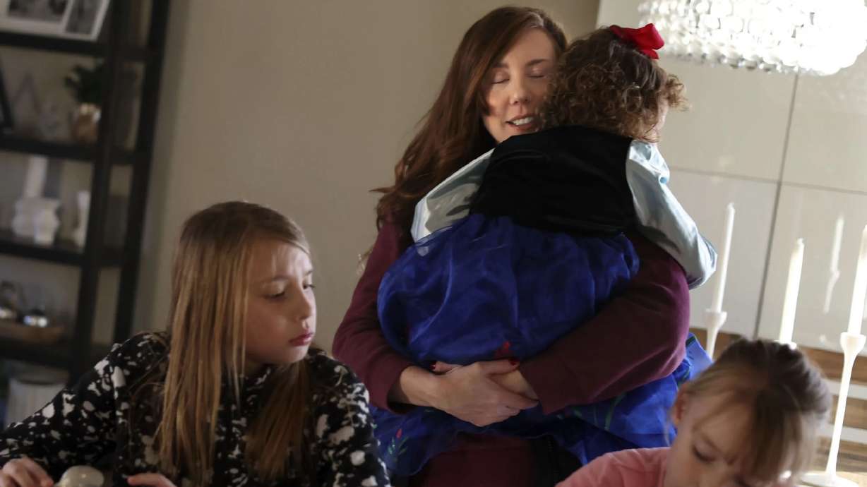 Shay Baker hugs her youngest daughter, Junie, 3, as Holland, 9, and Maxwell, 7, have an after-school snack at their Layton home on Wednesday. A new report examines the rate of labor force participation by women in Utah.
