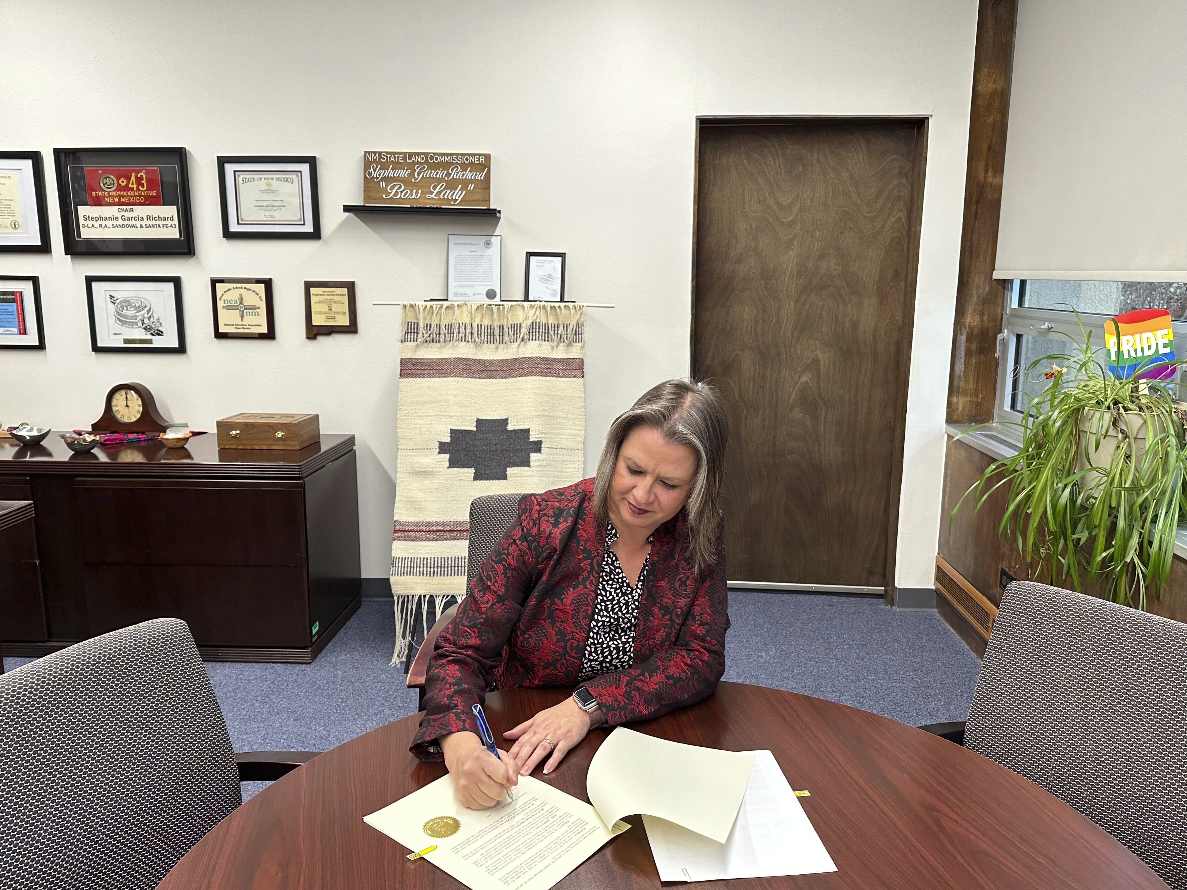 Land Commissioner Stephanie Garcia Richard in her office in Santa Fe, New Mexico, signing an executive order extending a moratorium on new oil and gas leasing in state trust land surrounding the Chaco Culture National Historical Park Wednesday.