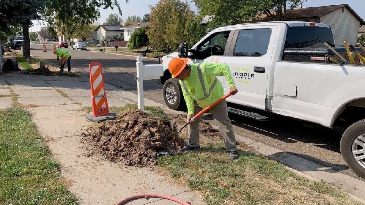 An unidentified UTOPIA Fiber employee helps install a broadband network in West Point in January 2020.