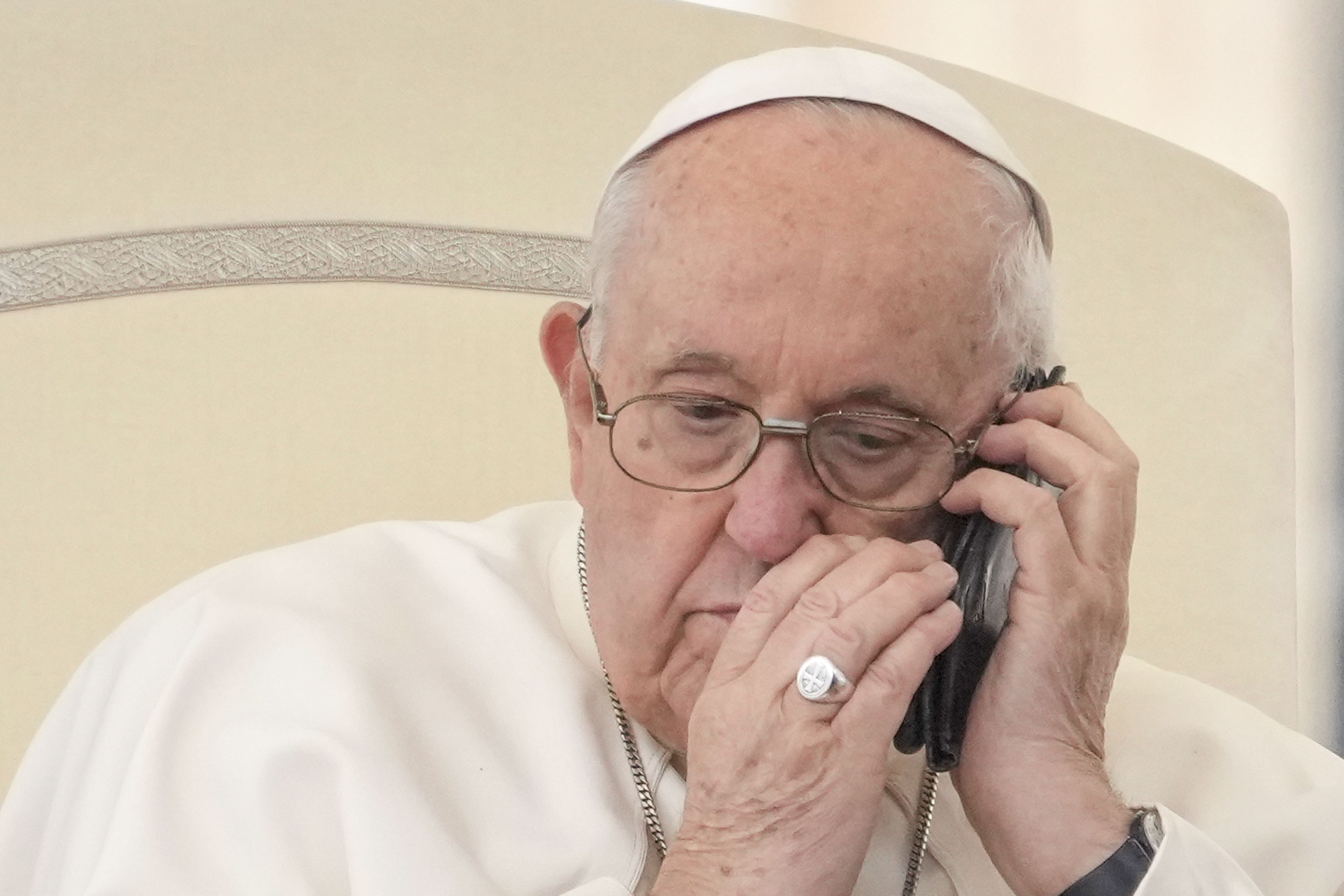 Pope Francis talks on the phone in the St. Peter’s Square at the Vatican on May 17. The victim of a fake AI-generated image earlier this year, he is calling for an international treaty to regulate the development and use of artificial intelligence.
