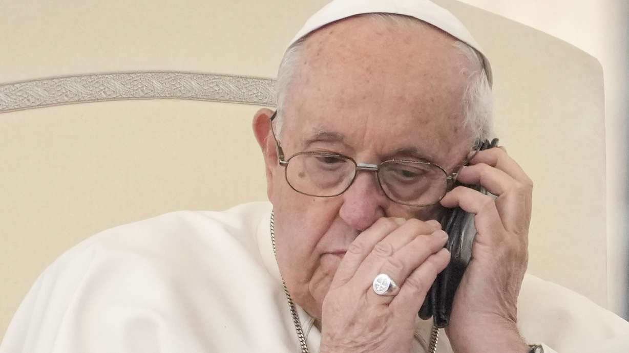 Pope Francis talks on the phone in the St. Peter’s Square at the Vatican on May 17. The victim of a fake AI-generated image earlier this year, he is calling for an international treaty to regulate the development and use of artificial intelligence.