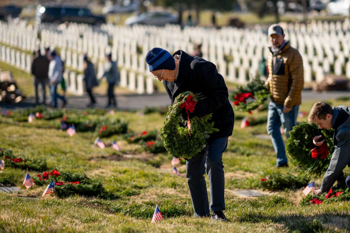 Ralph Gochnour, 89, lays wreaths on veterans’ graves as part of the Wreaths Across America program at the Salt Lake City Cemetery in Salt Lake City on Saturday.