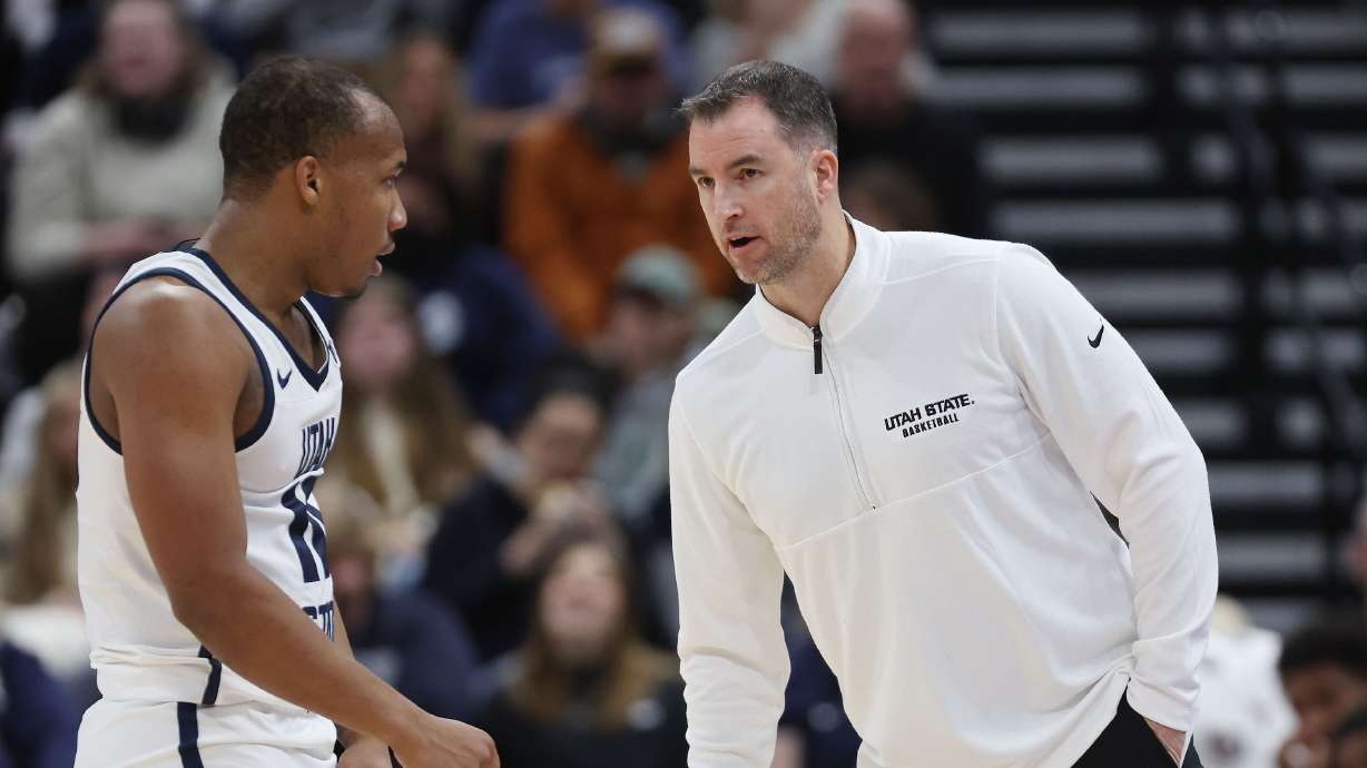 Utah State Aggies head coach Danny Sprinkle talks with Utah State Aggies guard Darius Brown II (10) against San Francisco Dons at the Delta Center in Salt Lake City on Saturday, Dec. 16, 2023. USU won 54-53.