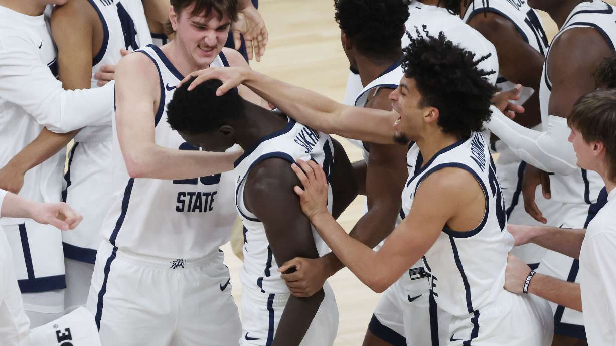 Utah State Aggies celebrate the win over the San Francisco Dons at the Delta Center in Salt Lake City on Saturday, Dec. 16, 2023. USU won 54-53.