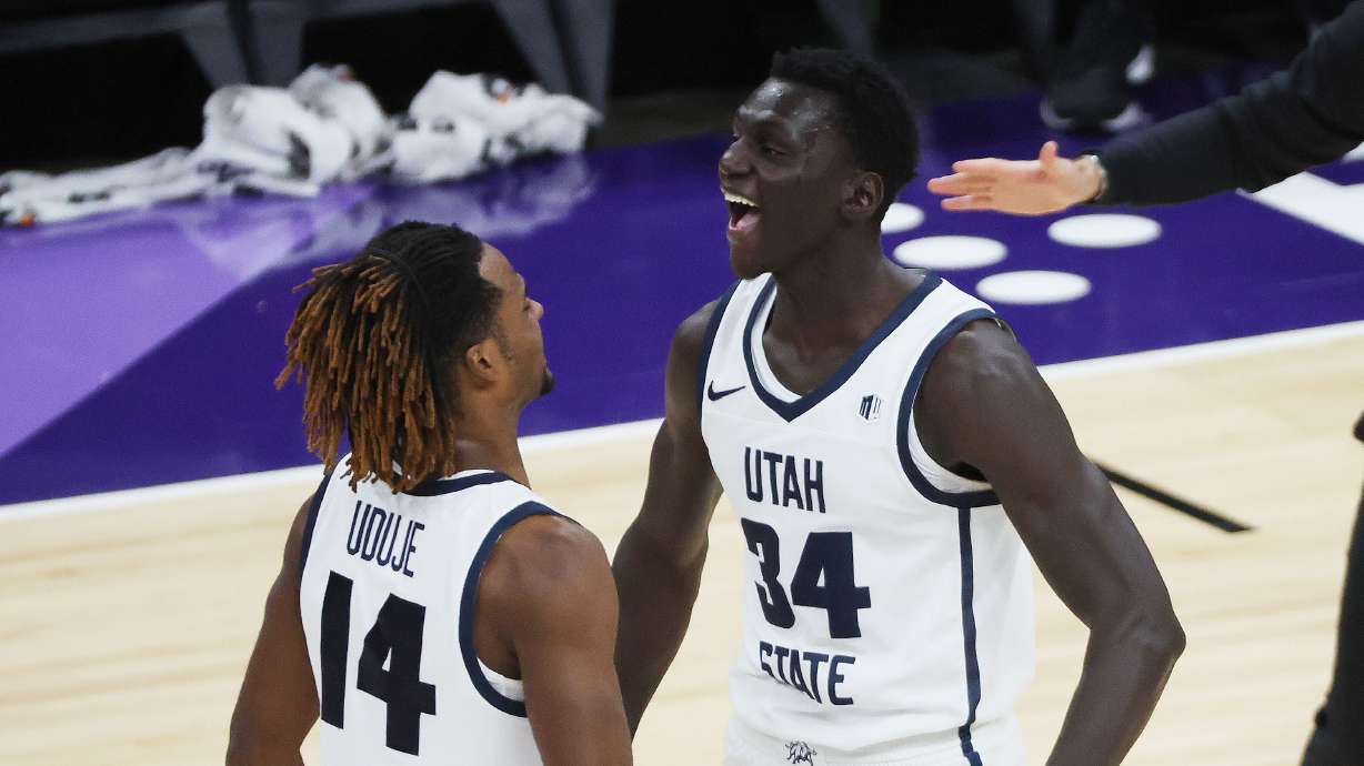 Utah State Aggies guard Josh Uduje (14) and Utah State Aggies forward Kalifa Sakho (34) celebrate the win over the San Francisco Dons at the Delta Center in Salt Lake City on Saturday, Dec. 16, 2023. USU won 54-53.