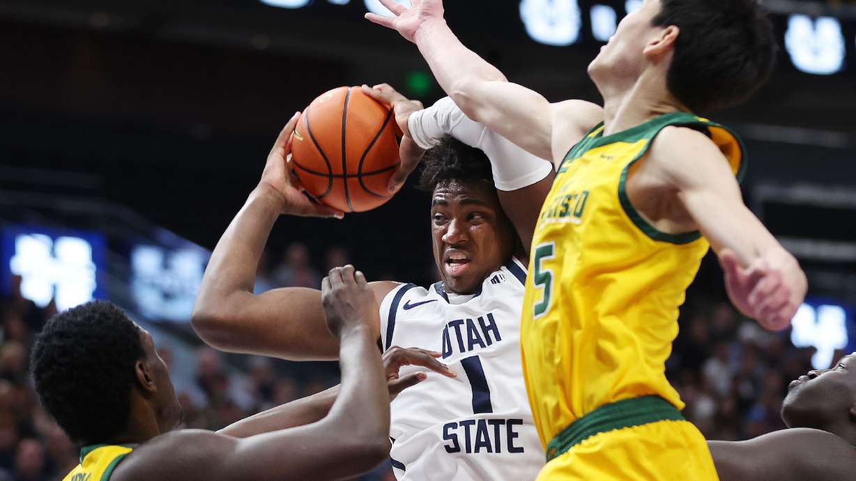 Utah State Aggies forward Kalifa Sakho (34) drives on San Francisco Dons guard Mike Sharavjamts (5) at the Delta Center in Salt Lake City on Saturday, Dec. 16, 2023.