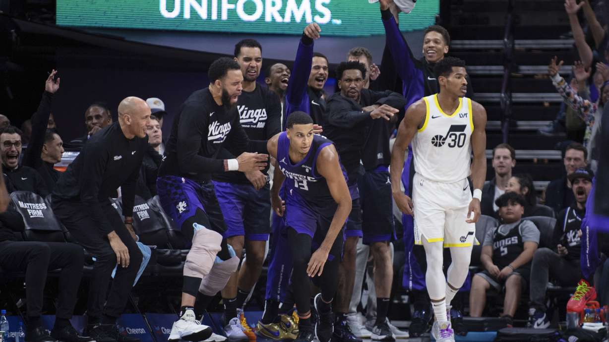 Sacramento Kings on the bench celebrate a 3-pointer by forward Keegan Murray (13) against Utah Jazz guard Ochai Agbaji (30) during the second half of an NBA basketball game in Sacramento, Calif., Saturday, Dec. 16, 2023.