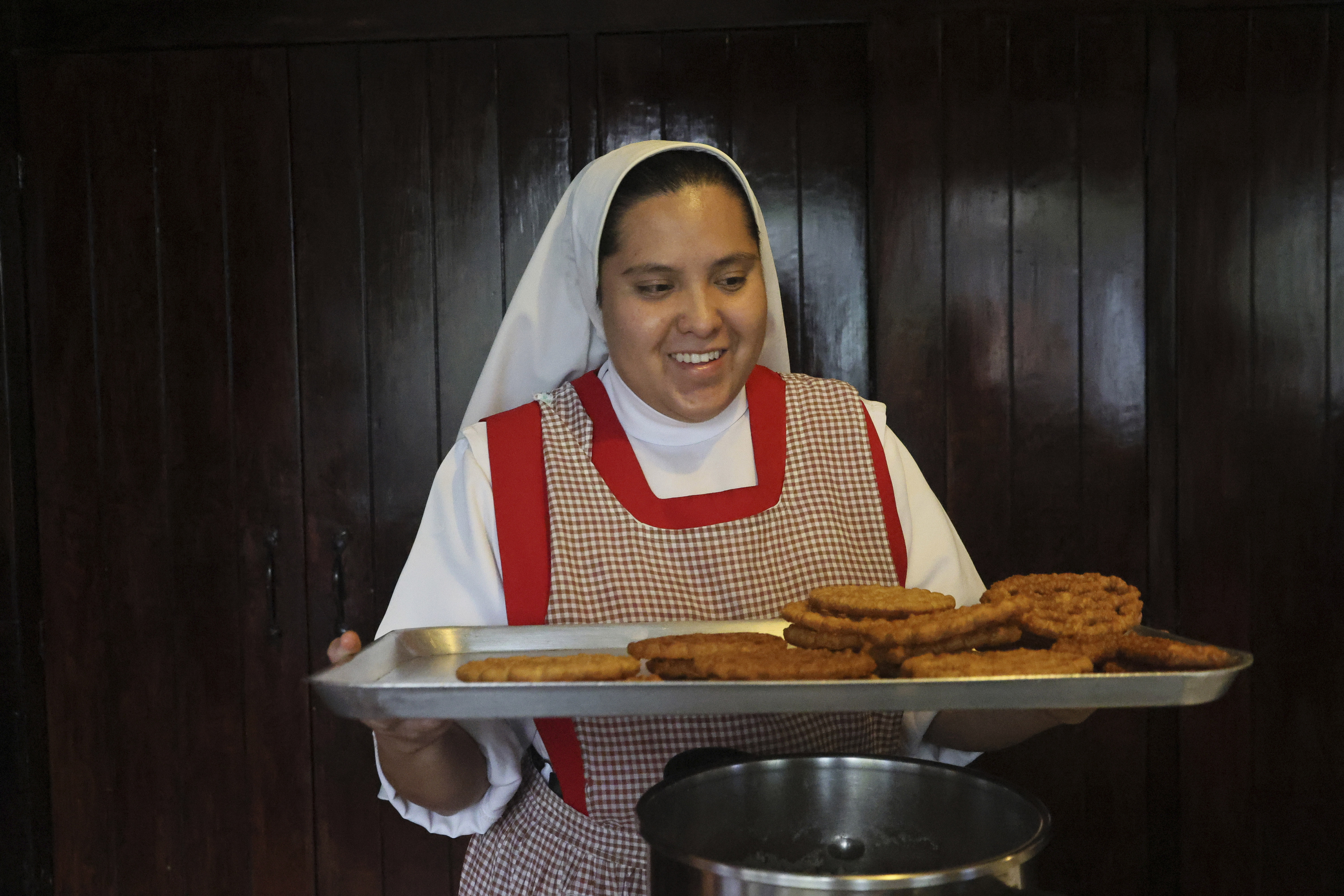Nun Maria de Jesus Frayle, 24, holds a tray with fried Christmas figures at the Mothers Perpetual Adorers of the Blessed Sacrament convent in Mexico City, Dec. 7.