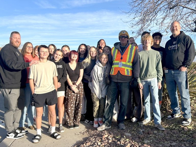 Students and faculty from preschool and middle school gather around Chris Godfrey, a beloved crossing guard in St. George.