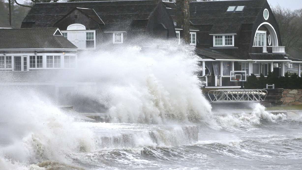 High winds drive surf into a retaining wall in front of a residence in Mattapoisett, Mass. on Monday, as a storm makes its away across the region.