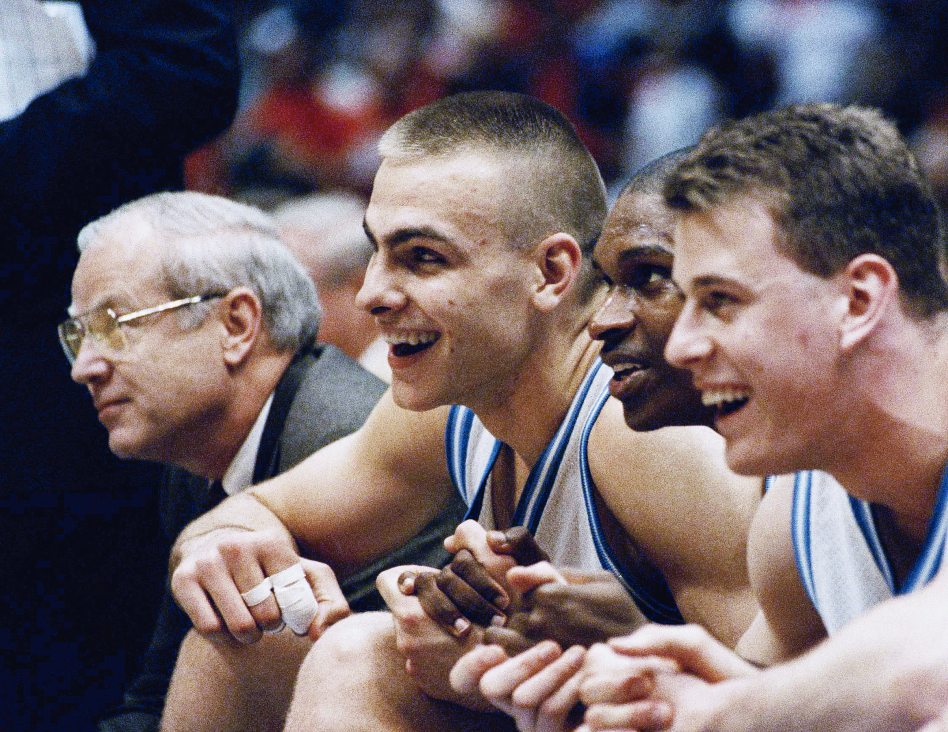 FILE - From left, North Carolina's Eric Montross, Donald Williams and Pat Sullivan smile as they hold hands and sit out the last seconds of their overtime victory against Cincinnati at the NCAA East Regional Final in the Meadowlands Arena on March 28, 1993 in East Rutherford, N.J. Montross, the former North Carolina and NBA big man, has died after a cancer fight, his family said. He was 52. The school released the family's announcement Monday morning, Dec. 18, 2023 saying Montross died Sunday surrounded by loved ones at his Chapel Hill home. He had been diagnosed with cancer in March, leading to him stepping away from his duties as a radio analyst for UNC game broadcasts.