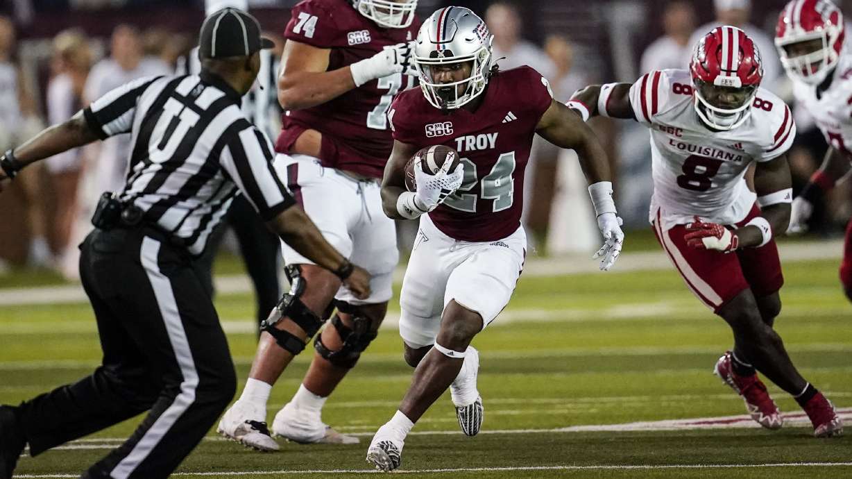Troy running back Damien Taylor (24) runs against Louisiana-Lafayette linebacker K.C. Ossai (8) during the second half of an NCAA college football game, Saturday, Nov. 18, 2023, in Troy, Ala.