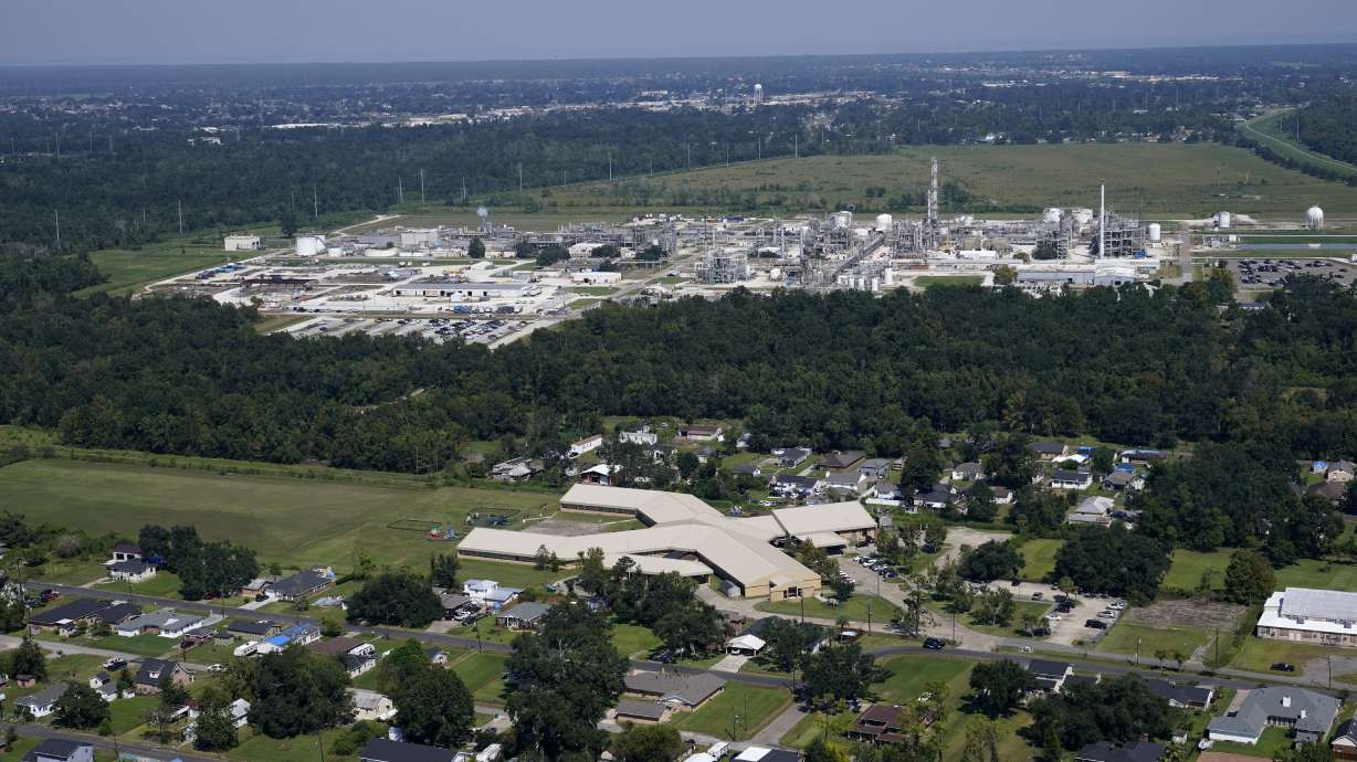 The Fifth Ward Elementary School and neighborhoods sit near the Denka Performance Elastomer Plant, back, in Reserve, La., Sept. 23, 2022. The EPA sued the company arguing that the plant posed a cancer risk to the mostly-Black community nearby.