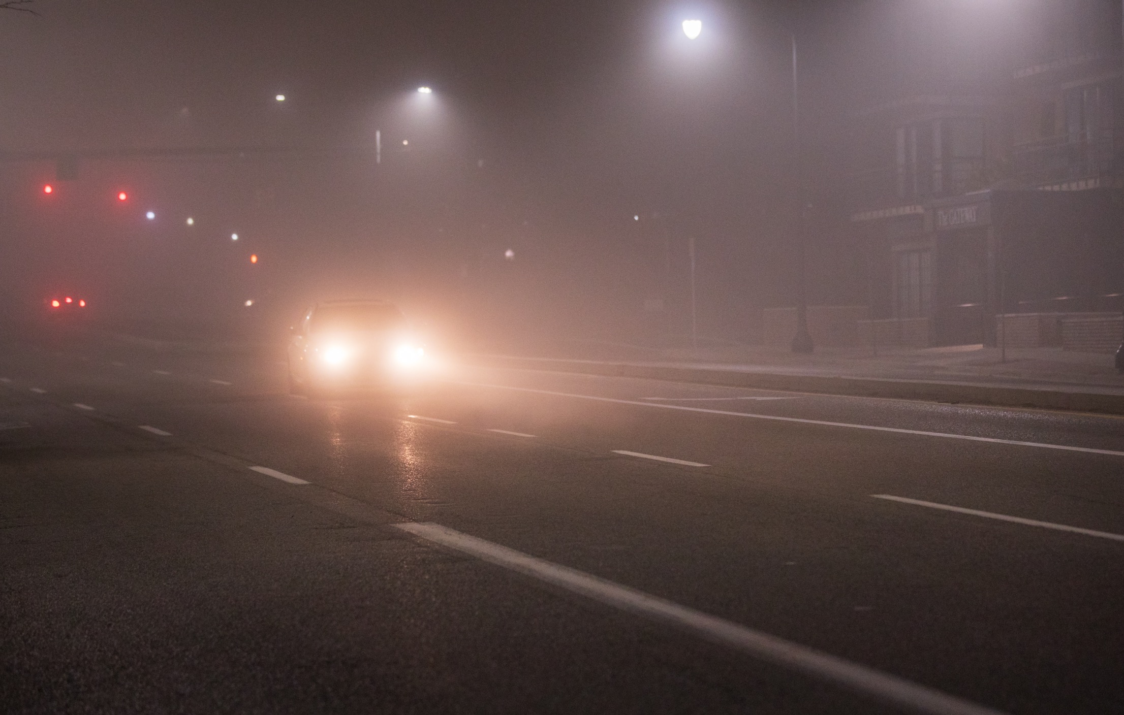 A car travels through fog on State Street in Salt Lake City on Sunday.