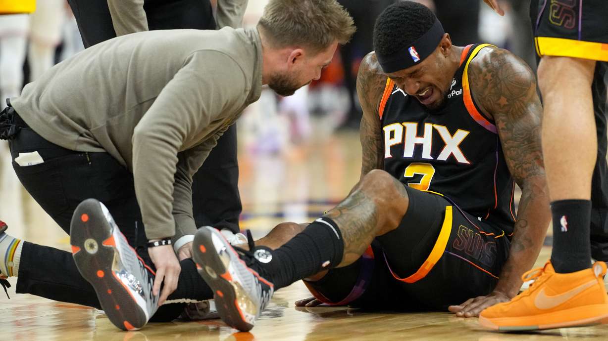 Phoenix Suns guard Bradley Beal (3) sits on the court after an injury against the New York Knicks during the first half of an NBA basketball game, Friday, Dec. 15, 2023, in Phoenix.