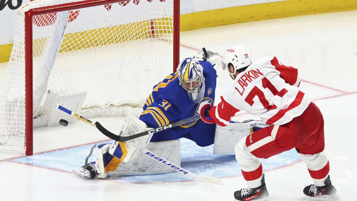 Buffalo Sabres goaltender Eric Comrie (31) stops Detroit Red Wings center Dylan Larkin (71) during the third period of an NHL hockey game Tuesday, Dec. 5, 2023, in Buffalo, N.Y.