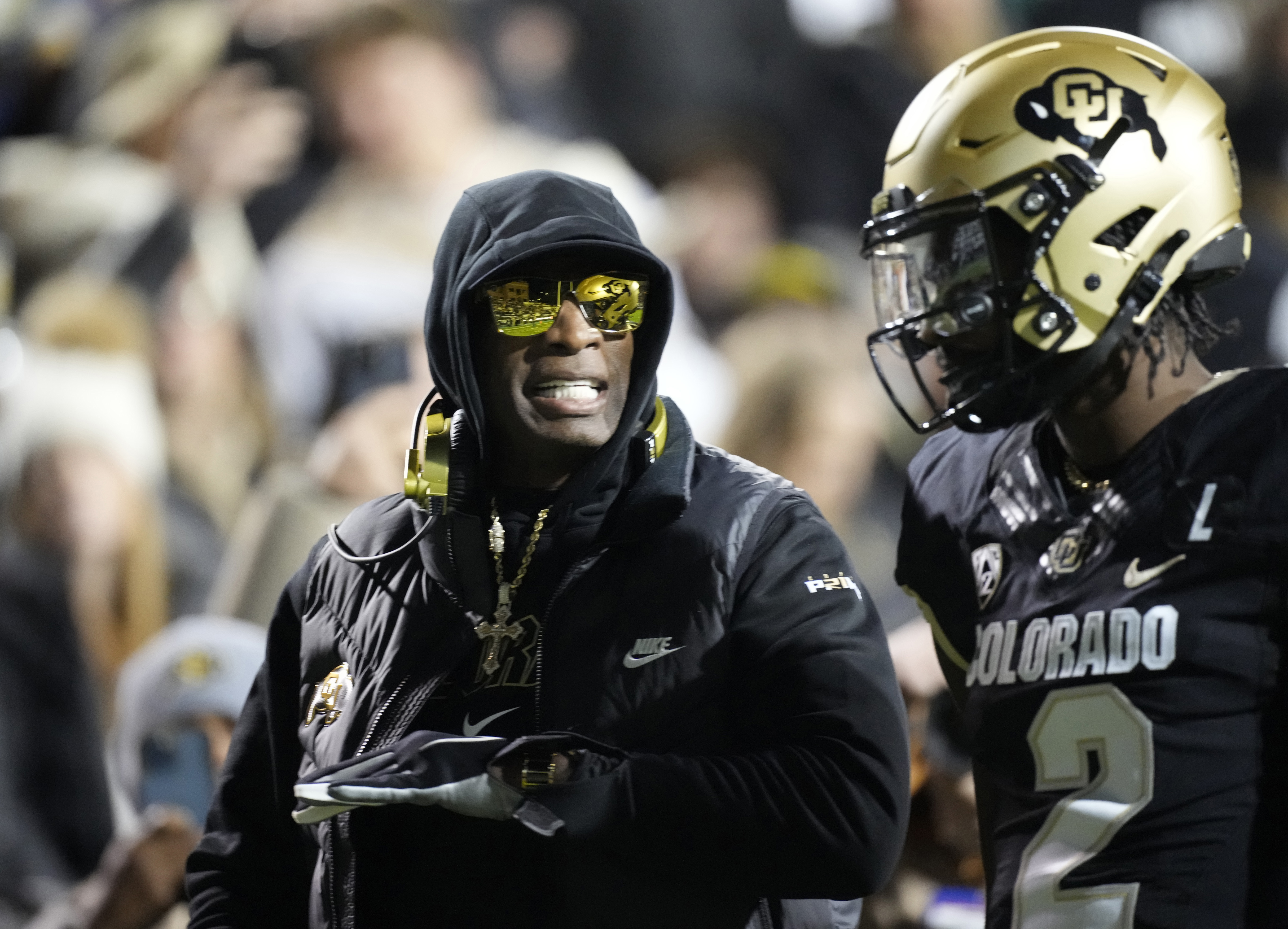 FILE - Colorado head coach Deion Sanders, left, talks to his son, quarterback Shedeur Sanders, in the first half of an NCAA college football game against Stanford Friday, Oct. 13, 2023, in Boulder, Colo. Deion Sanders is accomplishing what he pledged to do by overhauling his offensive line to better protect his often-hit quarterback son. The Colorado coach reached into the transfer portal and brought in linemen from the University of Houston, Connecticut, Indiana and UTEP. 